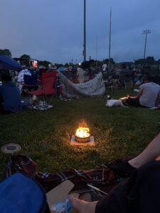 a group of people sitting around a campfire at Night Lights Festival