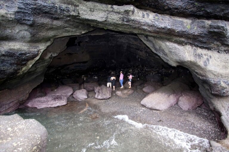 People exploring a rocky cave.