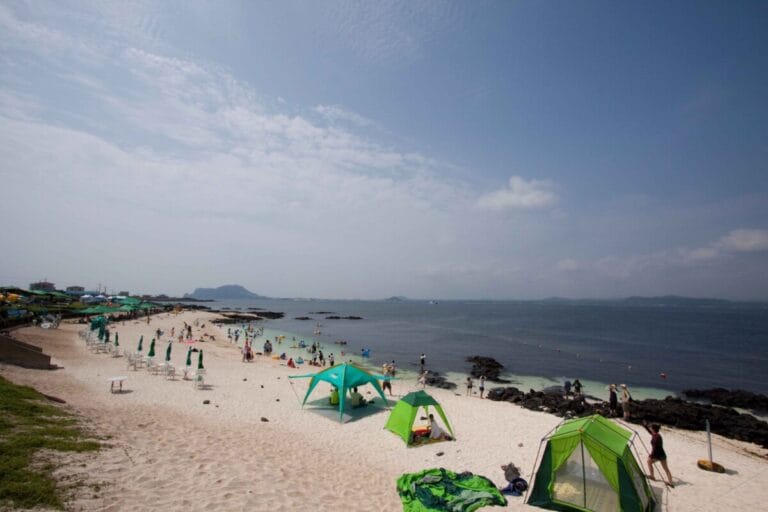  near Island restaurant Sunny beach with green tents.
